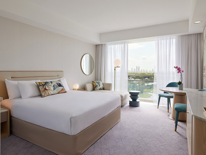 Superior king room at RACV Royal Pines, featuring a king bed, couch and desk.
