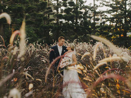 Bride and groom posing in a field at the Royal Pines resort.