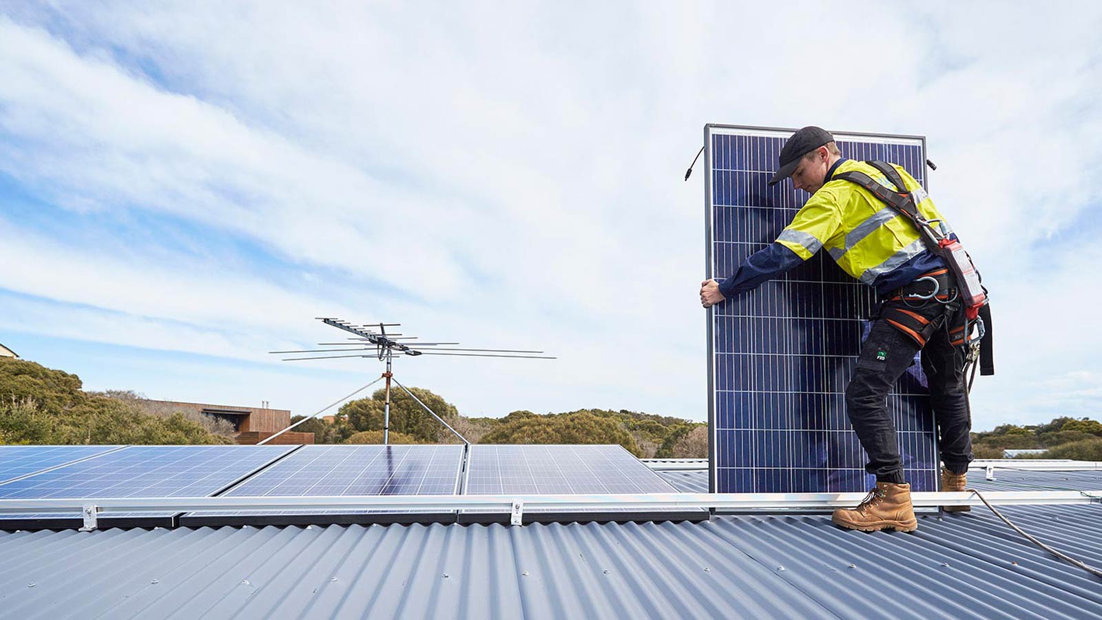 Tradesperson installing a solar panel on a property.