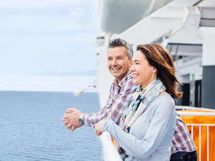A couple on the Spirit of Tasmania, smiling while looking at the ocean. 