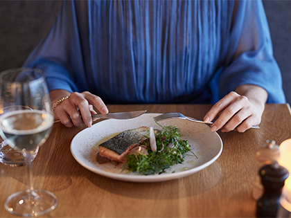 Person eating a salmon dish at RACV Torquay Resort's Number One restaurant.