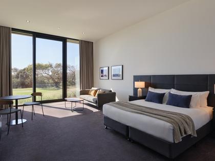 Golf view room at RACV Torquay Resort, featuring a king bed, couches and desk.