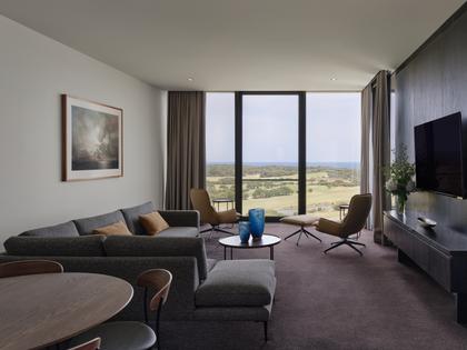 Ocean Spa Suite at RACV Torquay Resort, featuring a king bed, couches and desk.