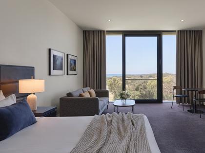 Premium ocean view room at RACV Torquay Resort, featuring a king bed, desk and couch.