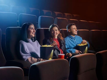 Three people watching a film at the cinema.