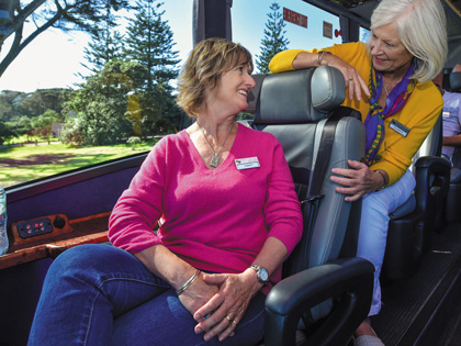Two women talking on a tour bus  